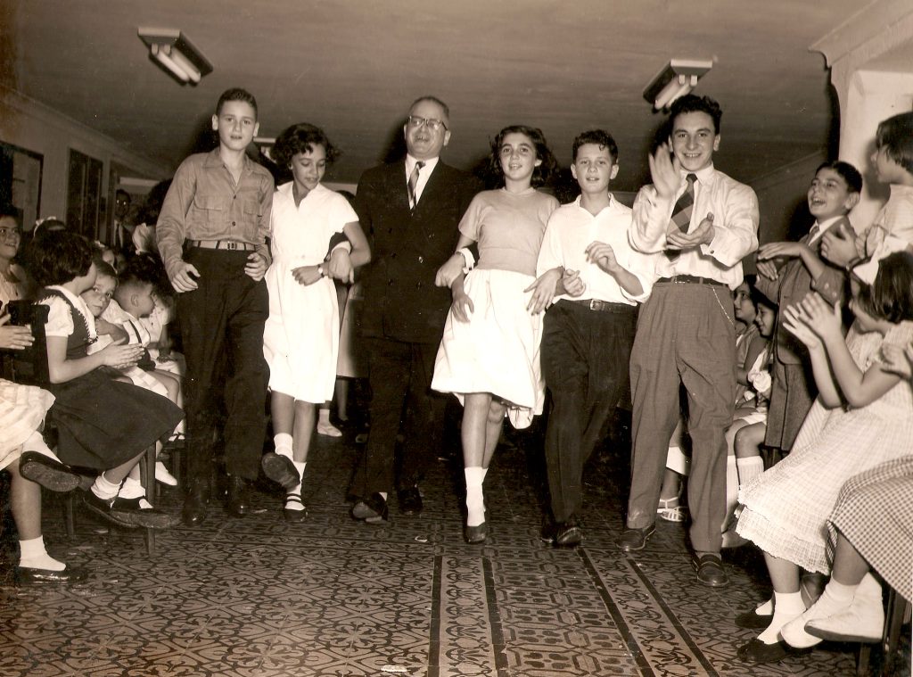 Jovens do grupo Hashmonaim dançam com o rabino Lemle ao centro